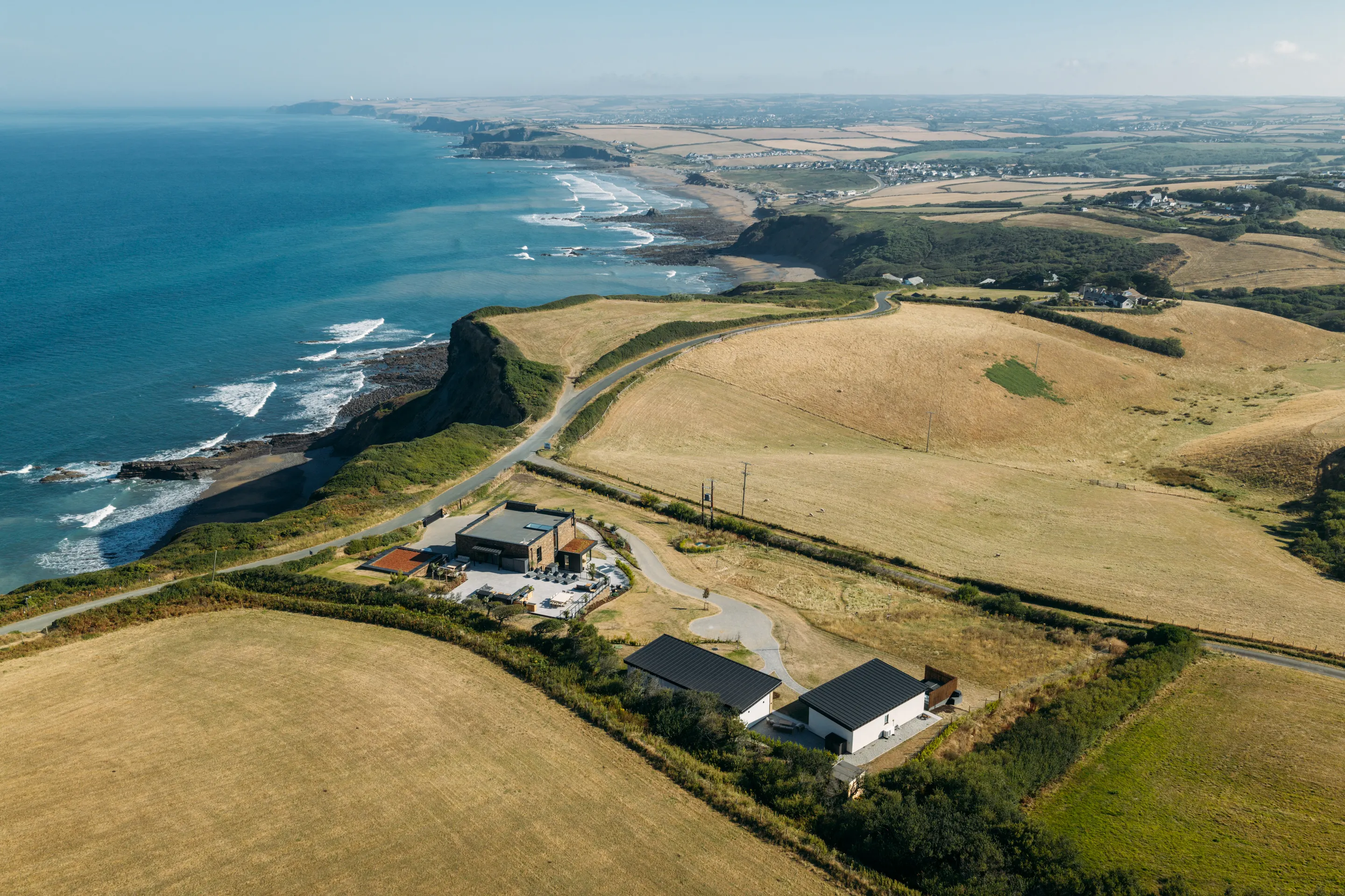Aerial view of a coastal property and the surrounding North Cornwall coastline during a Perfect Stays shoot